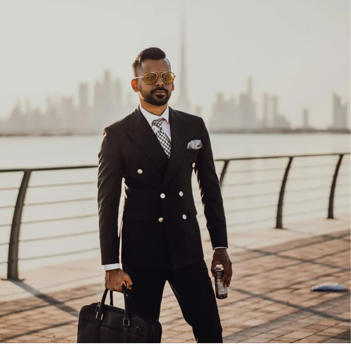 Product mock — a traveller in a dark suit on a Dubai waterfront.