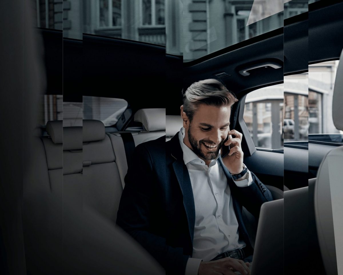 An image with a man talking to a phone in the back of the car, representing globally mobile people.