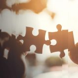 Hands holding two pieces of puzzle, representing family office technology solutions for better wealth management.