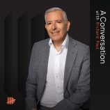 A picture of Richard Paul in front of a black background with the text stating 'In conversation with'.