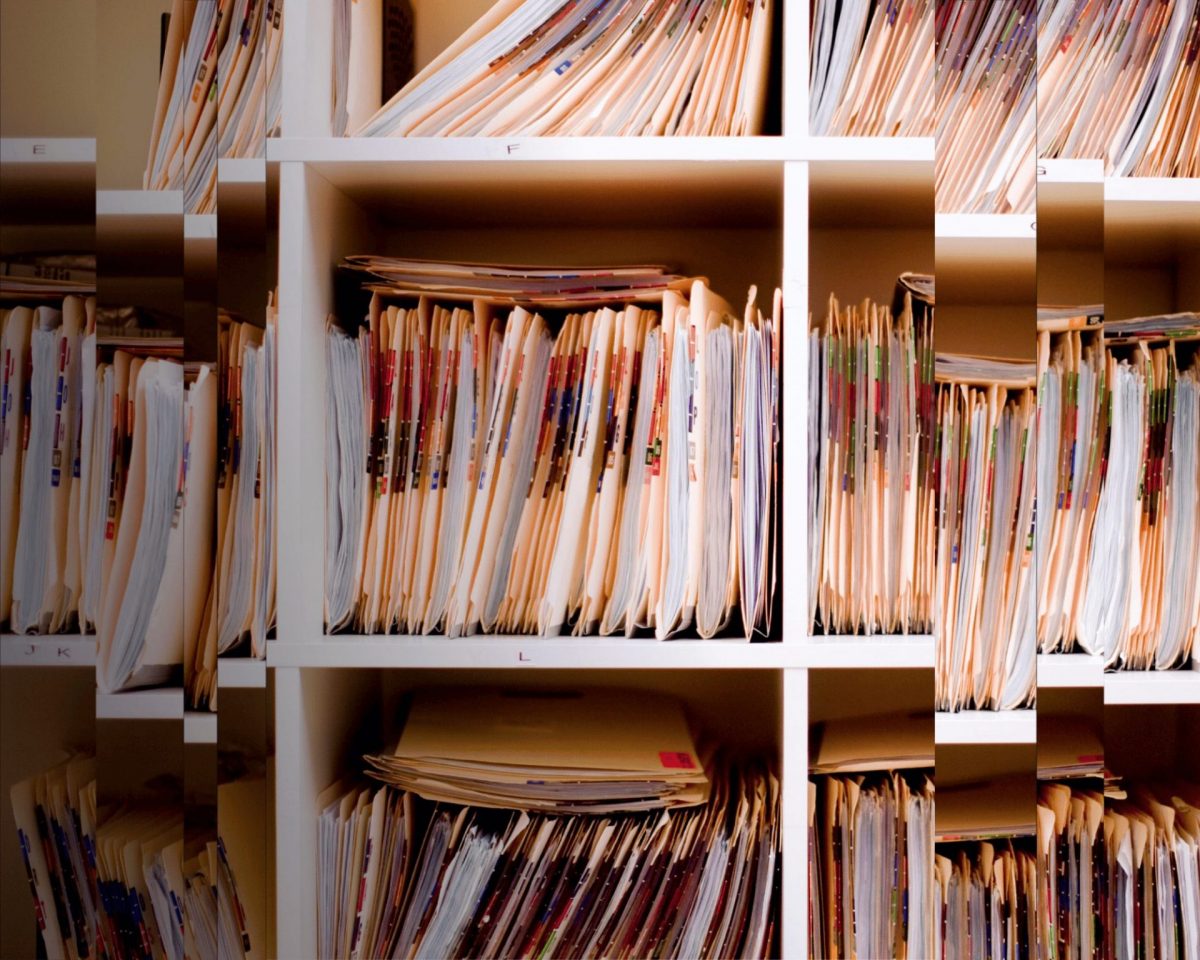 A distorted image of old files displayed on a shelf.