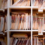 A distorted image of old files displayed on a shelf.