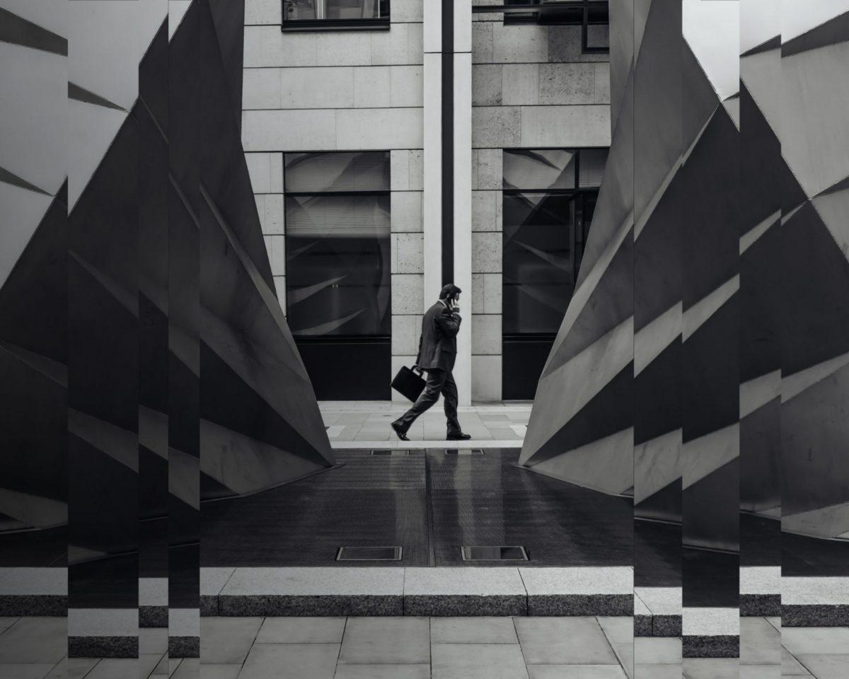 A black and white image of an advisor walking to a meeting.