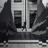 A black and white image of an advisor walking to a meeting.